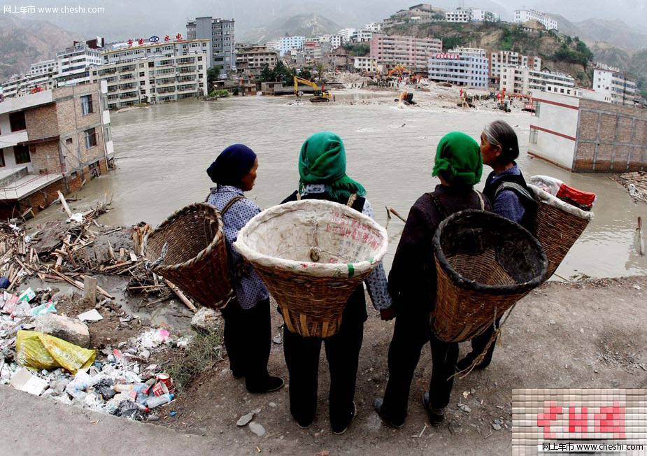 8月18日，甘肃舟曲泥石流灾区，一辆挖掘机将一辆被泥石流冲毁的小轿车从废墟中推了出来，让前来认领的车主将车拉走。