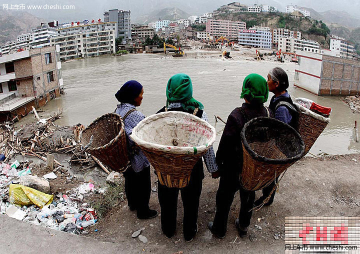 8月18日，甘肃舟曲泥石流灾区，一辆挖掘机将一辆被泥石流冲毁的小轿车从废墟中推了出来，让前来认领的车主将车拉走。