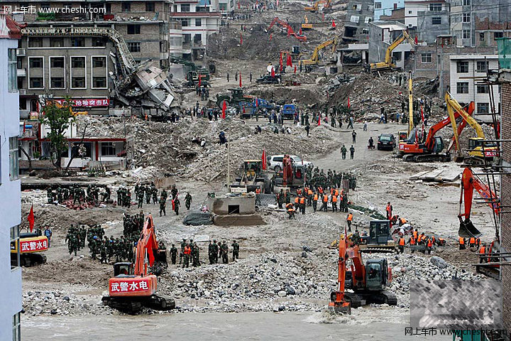 8月18日，甘肃舟曲泥石流灾区，一辆挖掘机将一辆被泥石流冲毁的小轿车从废墟中推了出来，让前来认领的车主将车拉走。